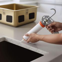 Kyselinovzdorné silikónové lepidlo na montáž nerezových umývadiel pod pracovnú dosku.